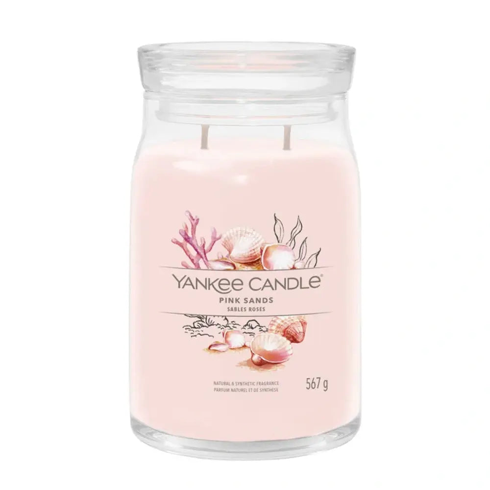 Une bougie rose pâle sur fond blanc